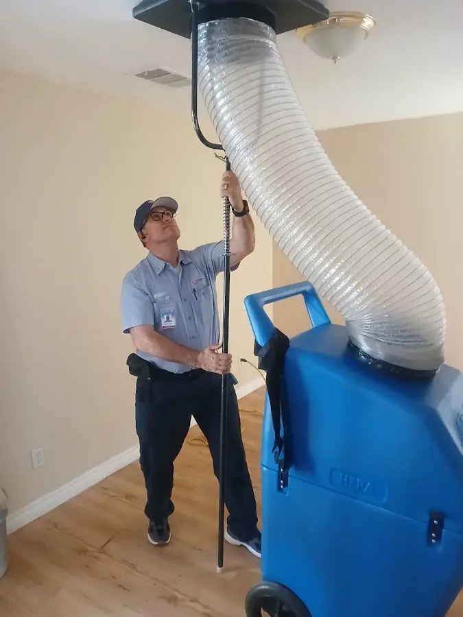 Furnace Tune-Up technician using HEPA equipment in Gonzales