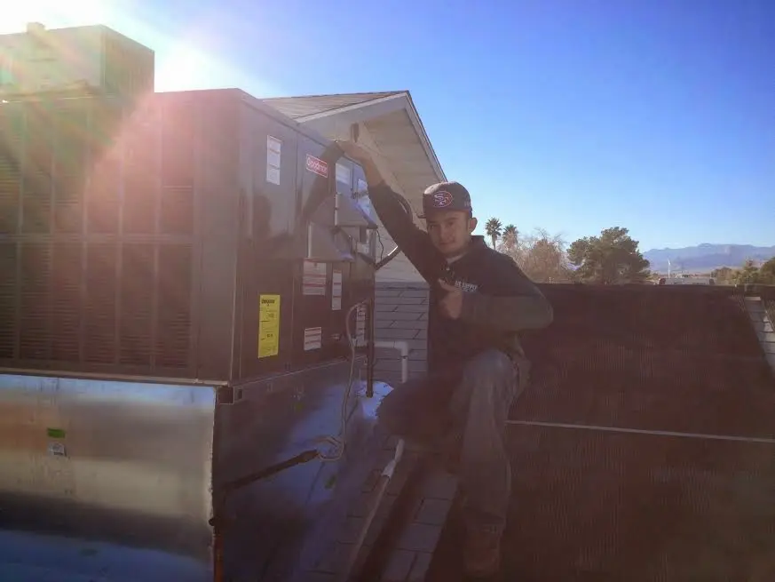 HVAC technician performing HVAC Inspection on a rooftop unit in Gonzales